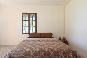 a bedroom with a bed and a window at TK Beach Resort Koh Mak in Ko Mak
