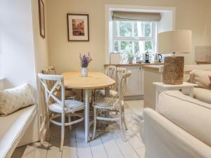cocina y sala de estar con mesa y sillas en Gate Lodge en West Calder