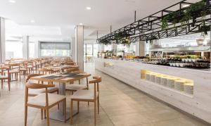 un restaurante con mesas y sillas de madera y una cafetería en Globales Maioris, en Maioris Décima
