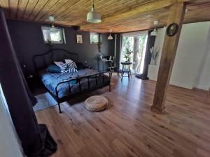 a bedroom with a bed and a table in a room at Lodge "Ezīša Midziņa" in Ķegums