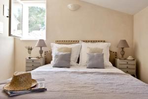 - une chambre avec un lit doté de draps et d'oreillers blancs dans l'établissement Cottage Aixois, à Aix-en-Provence