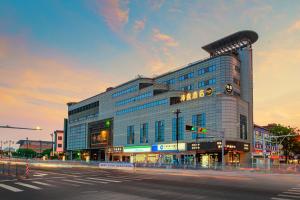 a large building on the corner of a street at PACE HOTEL Suzhou Renmin Branch in Suzhou