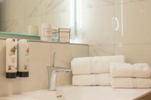 a bathroom with white towels and a sink and a mirror at Hotel Oberschmied in Reit im Winkl