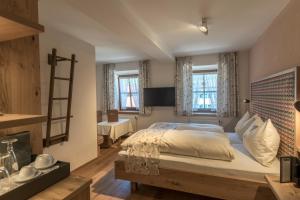 a bedroom with a large bed and two windows at Hotel Oberschmied in Reit im Winkl