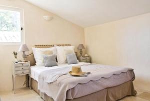 a bedroom with a large bed with a hat on it at Cottage Aixois in Aix-en-Provence