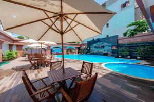 una mesa con sillas y una sombrilla junto a la piscina en Lao Cai Star Hotel, en Lào Cai