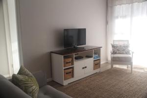 a living room with a tv on a cabinet at 9 Coogee Bay in East London