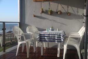 a table and chairs on a balcony with a view of the ocean at 9 Coogee Bay in East London