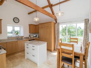 a kitchen with wooden cabinets and a table and chairs at Golden Valley Barn in Bristol