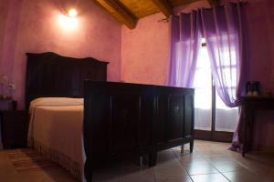 a bedroom with a bed and a window with purple curtains at Agriturismo La Cà Veja in Monforte dʼAlba +29 photos