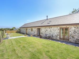 a stone house with a lawn in front of it at Y Bwthyn in Llanfairpwllgwyngyll