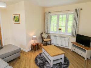a living room with a couch and a tv at Ryedale Country Lodges - Willow Lodge in York