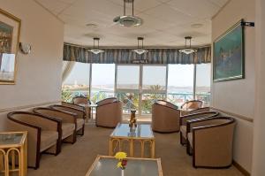 a waiting room with chairs and tables and windows at Sea-View Zum Sperrgebiet in Lüderitz