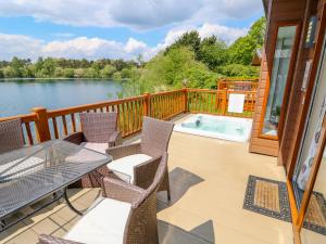 a deck with a table and chairs and a hot tub at 8 Castle View in Lincoln