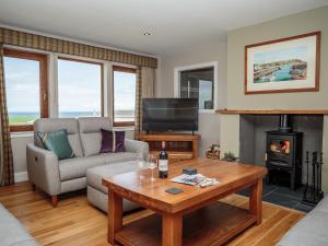 a living room with a couch and a table at Corsewall Castle Farm Lodges in Stranraer