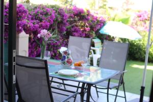 a table and chairs with purple flowers at Calanuza in El Campello