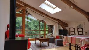 uma sala de estar com uma cama e uma grande janela em La Ferme des Andes - Gîte l'Atelier em Quins