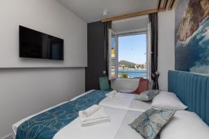 a hotel room with a bed with a large window at Apartments and Rooms Villa Naida in Dubrovnik