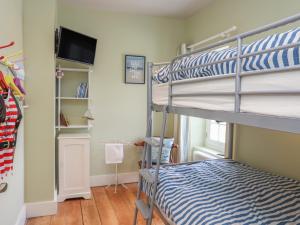 a bedroom with bunk beds and a flat screen tv at Gadlys House - Beau View in Beaumaris