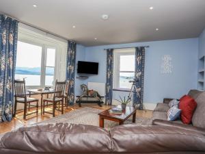 ein Wohnzimmer mit einem Sofa und einem Tisch in der Unterkunft Gadlys House - Waters Edge in Beaumaris