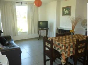 a living room with a table and a couch at Maga in Piriápolis