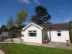 a white house with a patio in a yard at The Bungalow in Burnley