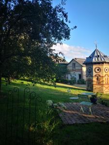 um jardim com uma mesa e uma torre do relógio em La Normandise em Cormeilles