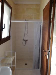 baño con cabina de ducha y ventana en Le stanze di Ray, en Borgagne