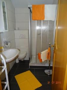 y baño con ducha, aseo y lavamanos. en Pension Strauss, en Sankt Lorenzen ob Murau
