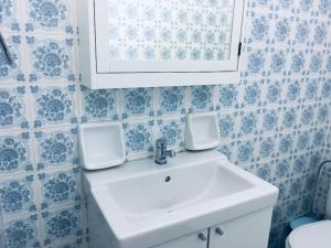 a bathroom with a sink and blue and white tiles at Angela Seaside Summer house in Dhílesi