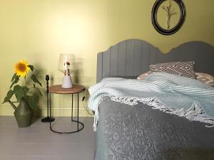 1 dormitorio con 1 cama y 1 mesa con lámpara en Au Sigala, en Lisle-sur-Tarn