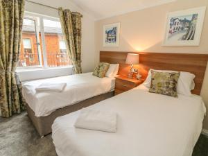 dwa łóżka w pokoju z oknem w obiekcie Bowness 66 w mieście Windermere