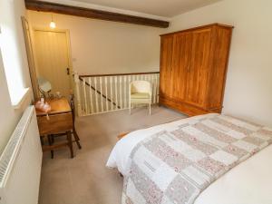 a bedroom with a bed and a desk and a chair at Spens Farm Cottage in Lancaster