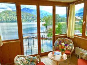 a room with large windows with a view of a lake at Hotel am See - Seeresidenz in Altaussee