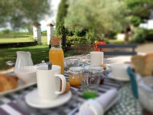 una mesa con platos de comida y una botella de zumo de naranja en Au Sigala, en Lisle-sur-Tarn