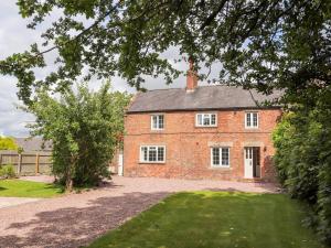 uma velha casa de tijolos com uma entrada em frente em Well House Farm Flat 2 em Chester