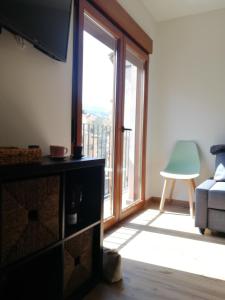 a living room with a large window and a couch at Apartamentos La Réunion in Camarena de la Sierra