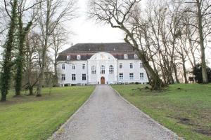 a large white house with a gravel road in front at Schloss Zinzow in Zinzow +82 photos