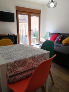 un soggiorno con tavolo, sedie e divano di Apartamentos La Réunion a Camarena de la Sierra