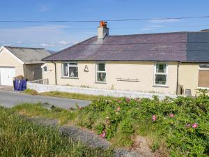 una casa al lado de una carretera con flores en Minydon, en Fairbourne