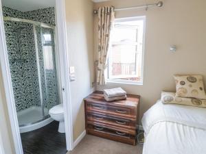 a bedroom with a bed and a bathroom with a shower at Booster's Lodge in Stratford-upon-Avon