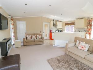 uma sala de estar com dois sofás e uma cozinha em Booster's Lodge em Stratford-upon-Avon