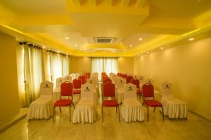 een vergaderzaal met rode en witte stoelen en tafels bij Hotel Task International in Pokhara