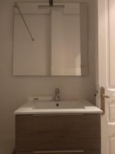 y baño con lavabo y espejo. en ordizia piso con vistas al parque en Villafranca de Ordizia