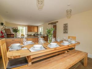 una cocina con una mesa de madera con platos y vasos. en Polstein, en Truro