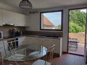 a kitchen with a glass table and a window at LA LOGIA DU SAULE in Rilly-la-Montagne