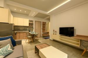 a living room with a couch and a kitchen at Sunny Luxury Suite Stone in Kavála