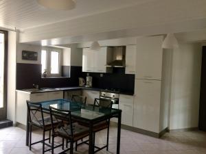 a kitchen with a glass table and chairs in it at Joli appartement de 60m2 avec Balcon à la campagne in Courson-les-Carrières