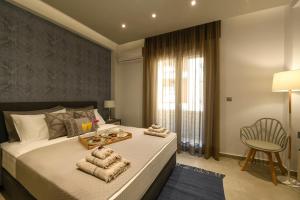 a bedroom with a bed with a chair and a window at Sunny Luxury Suite Stone in Kavála
