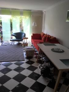 a living room with a red couch and a checkered floor at Dachstudio mit Bad und Terasse in Cologne
